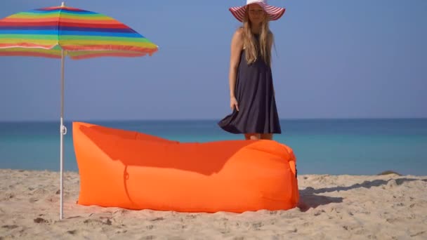 坐在热带海滩上的年轻女子躺在充气的沙滩上。暑假概念 — 图库视频影像