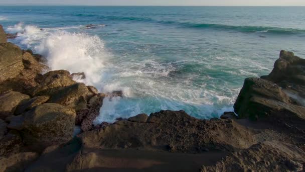 Slowmotion Steadicamnél shot a családi gyaloglás egy sziklás tengerparton egy Tanah Lot templom a Bali szigetén — Stock videók