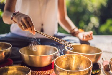 Tibet'te bir şelaleye karşı yoga minderinde otururken çalan kadın. Vintage tonlu. Mala boncuk meditasyon ile güzel kız