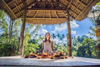 Tibet'te bir şelaleye karşı yoga minderinde otururken çalan kadın. Vintage tonlu. Mala boncuk meditasyon ile güzel kız