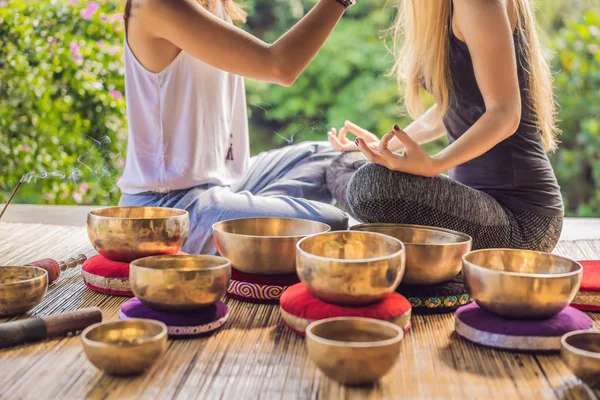 Nepal Buddha koppar sång skål på spa salong. Ung vacker kvinna som gör massage terapi sjunga skålar i Spa mot ett vattenfall. Ljudterapi, rekreation, meditation, hälsosam livsstil och — Stockfoto