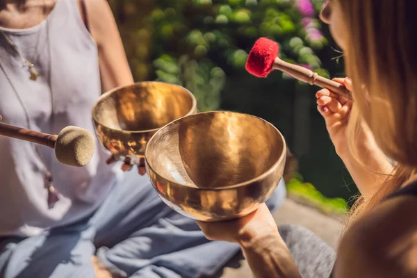 Spa salonunda Nepal Buda bakır kasesi. Genç, güzel bir kadın masaj terapisi yapıyor. Spa 'da şelaleye karşı kâseler söylüyor. Ses terapisi, dinlenme, meditasyon, sağlıklı yaşam tarzı ve...