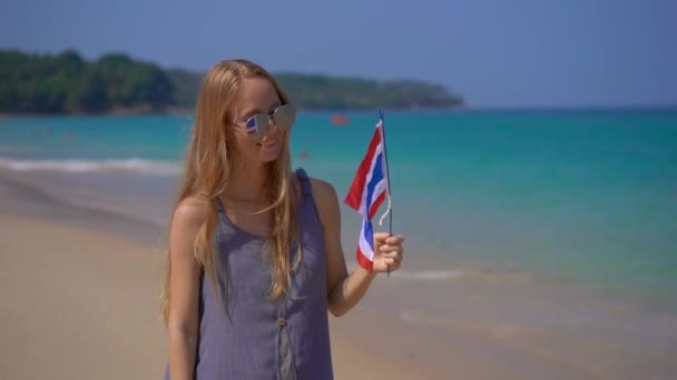 Superzeitlupe Aufnahme einer schönen jungen Frau mit reflektierender Sonnenbrille hält eine thailändische Nationalflagge am Strand — Stockvideo