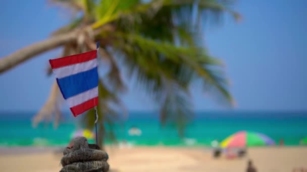 Superslowmotion skott av en nationell flagga av Thailand på en vacker strand. Tropiskt semesterkoncept. Resa till Thailand Concept — Stockvideo