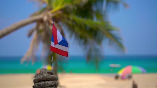 Superslowmotion skott av en nationell flagga av Thailand på en vacker strand. Tropiskt semesterkoncept. Resa till Thailand Concept — Stockvideo