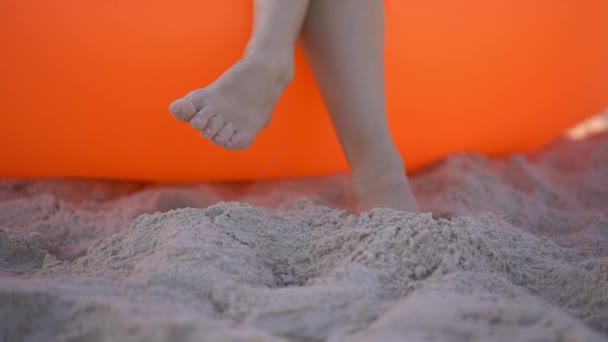 Slowmotion skott av en ung kvinna på en tropisk strand som sitter på en Uppblåsbar soffa. Sommarsemester koncept — Stockvideo