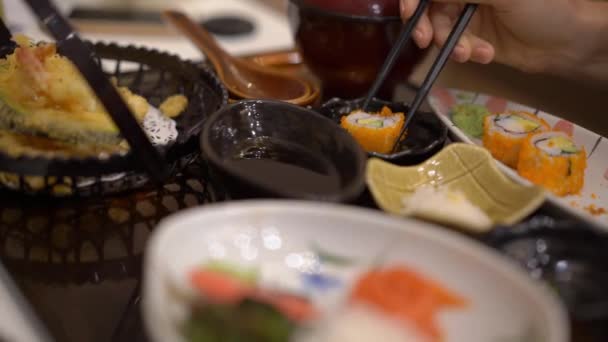 Slowmotion tiro de uma jovem que gosta de comida japonesa em um restaurante — Vídeo de Stock