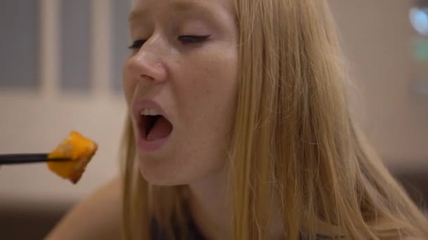 一个年轻女子在餐馆里吃日本料的慢动作镜头 — 图库视频影像
