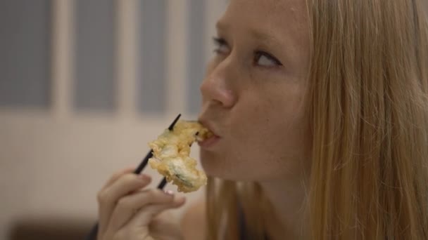 一个年轻女子在餐馆里吃日本料的慢动作镜头 — 图库视频影像