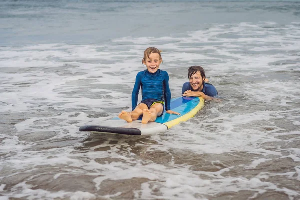 Vater oder Lehrer bringt seinem 5-jährigen Sohn im Urlaub oder Urlaub das Surfen im Meer bei. Reisen und Sport mit Kindern. Surfstunde für Kinder — Stockfoto