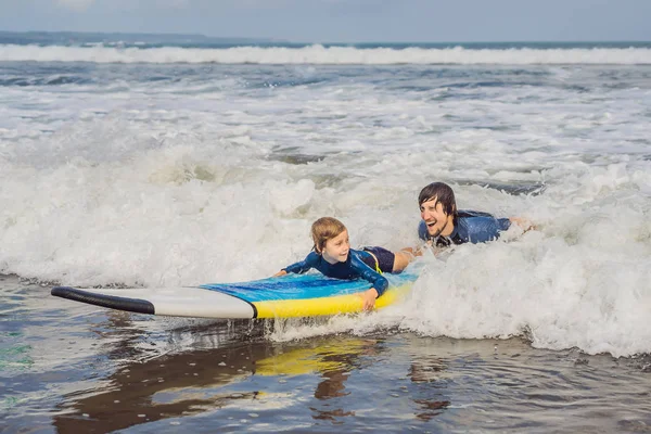 Apa vagy oktató tanítás az 5 éves fia, hogyan kell szörfözni a tengeren nyaralni, vagy ünnep. Utazás és a sport a gyermekek fogalmát. Szörfözés lecke gyerekeknek — Stock Fotó