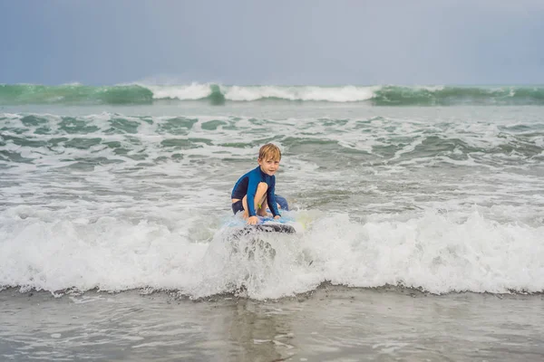 Padre o istruttore che insegna a suo figlio di 5 anni come navigare in mare in vacanza o in vacanza. Viaggio e sport con bambini concetto. Lezione di surf per bambini — Foto Stock