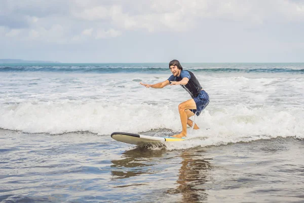 Surfista en la ola, coge una ola, surfeando en la tubería. Surfeando en el océano en la isla de Bali, un hombre suave, un salto al océano. Tomado del agua. Fotografiado desde el agua — Foto de Stock