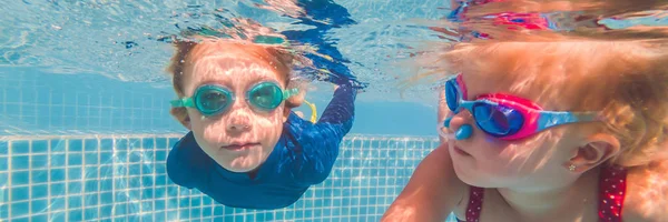 Los niños se divierten jugando bajo el agua en la piscina en las vacaciones de verano BANNER, FORMATO LARGO — Foto de Stock