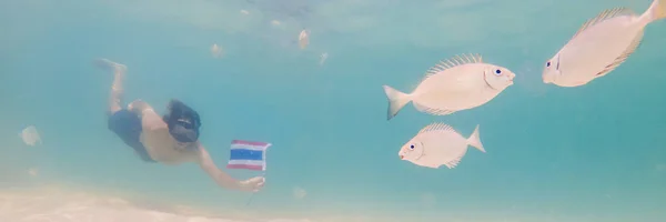 BANNER, FORMATO LARGO Hombre feliz en buceo máscara de snorkel bajo el agua con peces tropicales con bandera de Tailandia en el arrecife de coral piscina de mar. Vida de viaje, deportes acuáticos aventura al aire libre, clases de natación en — Foto de Stock