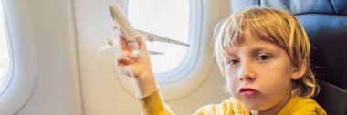 Küçük çocuk tatil Banner, Uzun Format uçan ticari jet uçağı oyuncak uçak ile oynamak