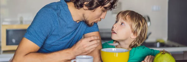 Father and son are talking and smiling while having a breakfast in kitchen BANNER, LONG FORMAT — Stock Photo, Image