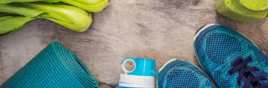 Banner, Uzun Format Spor turkuaz için her şey, ahşap bir arka plan ve ıspanak smoothies üzerinde mavi tonları. Yoga mat, spor ayakkabı spor giyim ve su şişesi. Kavram sağlıklı yaşam tarzı, spor