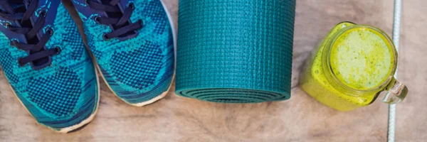 BANNER, FORMAT LONG Tout pour les sports turquoise, les nuances bleues sur fond bois et les smoothies aux épinards. Tapis de yoga, chaussures de sport vêtements de sport et bouteille d'eau. Concept mode de vie sain, sport — Photo