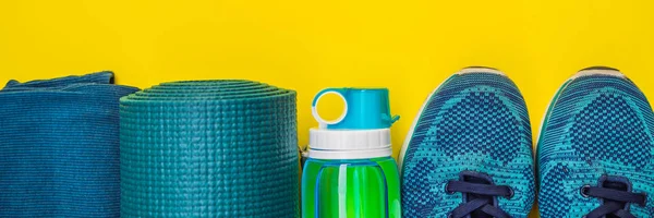 BANNER, LONG FORMAT Everything for sports turquoise, blue shades on a yellow background. Yoga mat, sport shoes sportswear and bottle of water. Concept healthy lifestyle, sport and diet. Sport