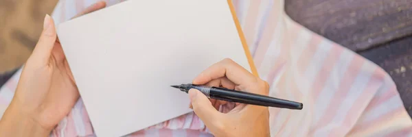 Manos de mujer en un fondo tropical sosteniendo un papel de letrero, maqueta BANNER, FORMATO LARGO —  Fotos de Stock