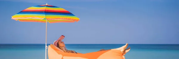 Stile di vita estivo ritratto di bella ragazza seduta sul divano gonfiabile arancione sulla spiaggia dell'isola tropicale. Rilassarsi e godersi la vita sul letto ad aria BANNER, FORMATO LUNGO — Foto Stock