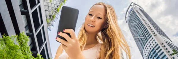 Vrouw met behulp van kaart app op smartphone op de achtergrond van wolkenkrabbers banner, lang formaat — Stockfoto