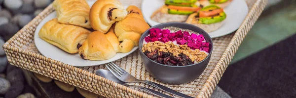 Café da manhã em uma bandeja com frutas, pães, sanduíches de abacate, tigela de smoothie na piscina. Dieta saudável de verão, café da manhã vegan. Conceito de férias saboroso BANNER, LONG FORMAT — Fotografia de Stock