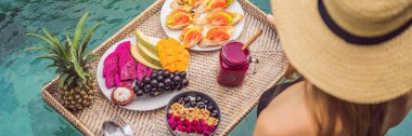 Banner, Uzun Format Yüzme Havuzunda Kahvaltı tepsisi, lüks otelde yüzen kahvaltı. Havuzda dinlenen kız smoothies içme ve meyve tabağı, otel havuzu yanında smoothie kase yemek. Egzotik