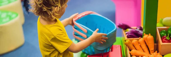 Junge kauft Obst und Gemüse im Spielzeug-Supermarkt ein, Großformat — Stockfoto