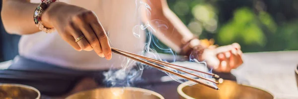 Vrouw spelen op Tibetaanse Singing Bowl terwijl zittend op yoga mat tegen een waterval. Vintage tonned. Mooi meisje met Mala kralen mediteren banner, lang formaat — Stockfoto