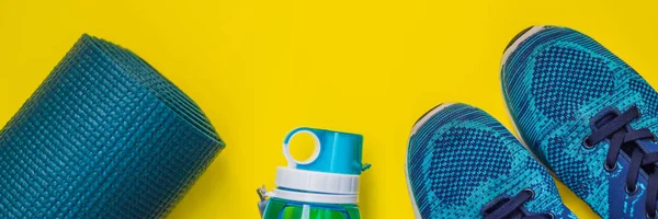 BANNER, LONG FORMAT Everything for sports turquoise, blue shades on a yellow background. Yoga mat, sport shoes sportswear and bottle of water. Concept healthy lifestyle, sport and diet. Sport