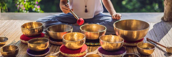 Vrouw spelen op Tibetaanse Singing Bowl terwijl zittend op yoga mat tegen een waterval. Vintage tonned. Mooi meisje met Mala kralen mediteren banner, lang formaat — Stockfoto