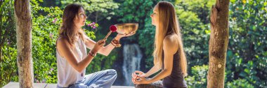 Banner, Uzun Format Nepal Buda bakır spa salonunda kase şarkı kase. Genç güzel kadın bir şelale karşı Spa'da şarkı kase masaj terapisi yapıyor. Ses terapisi, rekreasyon, meditasyon