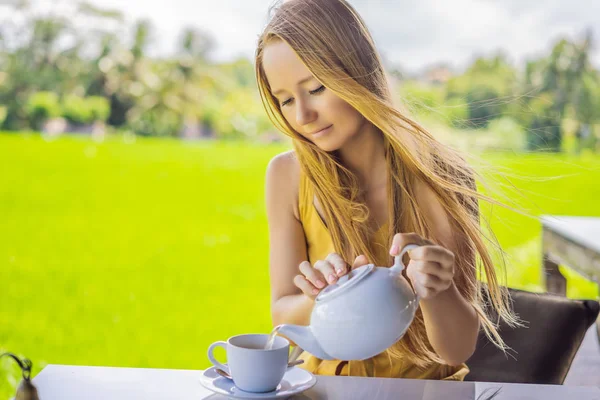 Mulher com uma xícara de chá na varanda do café perto dos terraços de arroz em Bali, Indonésia — Fotografia de Stock