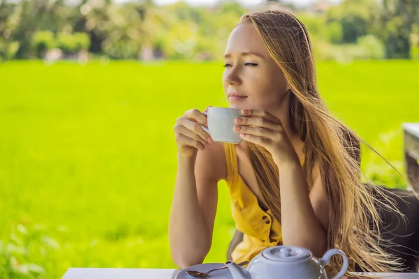 Bali, Endonezya pirinç terasları yakınında kafe verandada çay bir fincan ile Kadın