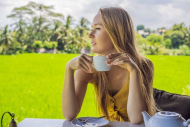 Bali, Endonezya pirinç terasları yakınında kafe verandada çay bir fincan ile Kadın