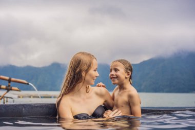 Bali Hot Springs anne ve oğlu gezginler gölün arka planda. Çocuk konsepti ile seyahat