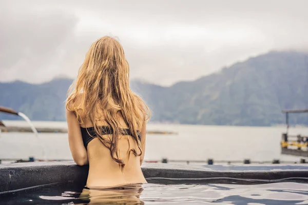 Spa geotermal. Mujer relajándose en la piscina termal contra el lago. concepto de aguas termales —  Fotos de Stock