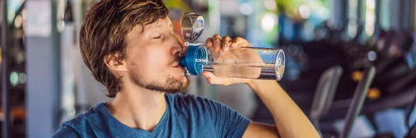 Sport man dricksvatten i gymmet banner, lång format — Stockfoto