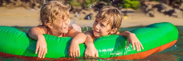 Los niños nadan en el mar en un colchón inflable y se divierten BANNER, FORMATO LARGO —  Fotos de Stock