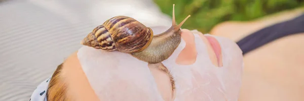 Jovem faz uma máscara facial com muco de caracol. Caracol rastejando em uma máscara facial BANNER, LONG FORMAT — Fotografia de Stock