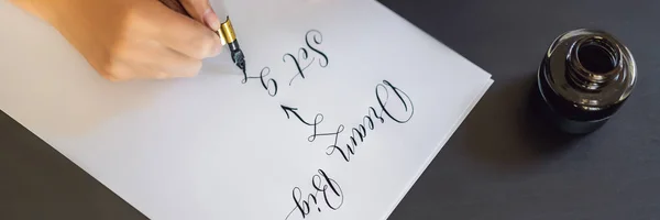 Banner, lang gehegte Träume werden in die Tat umgesetzt. Kalligraph junge Frau schreibt Satz auf weißem Papier. Inschrift ornamental verzierte Buchstaben. Kalligrafie, Grafikdesign, Schrift, Handschrift — Stockfoto