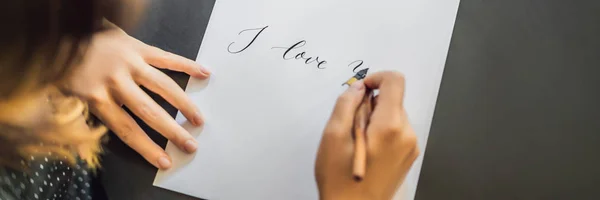 Je t'aime. La calligraphe Young Woman écrit une phrase sur un livre blanc. Inscrire des lettres ornementales décorées. Calligraphie, graphisme, lettrage, écriture, concept de création BANNER, FORMAT LONG — Photo