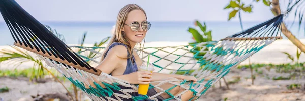 Jovem mulher na praia em uma rede com uma bebida BANNER, LONG FORMAT — Fotografia de Stock