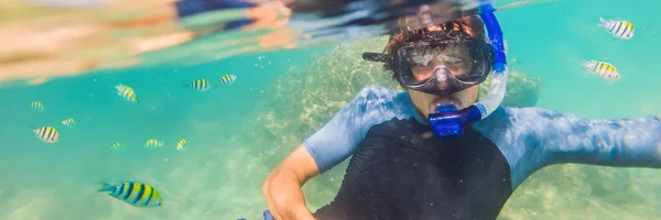 Fiatal férfiak snorkeling feltárása víz alatti korallzátonyok táj háttérben a mély kék óceán színes hal és a tengeri élet banner, hosszú formátum — Stock Fotó