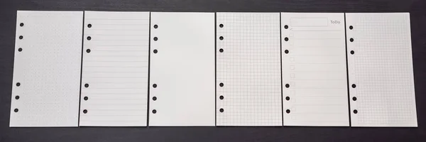 Different paper for notepad mocap on a black wooden background BANNER, LONG FORMAT — Stock Photo, Image