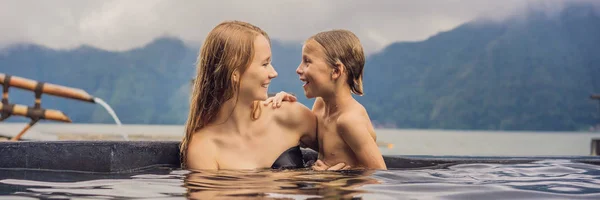 Mamá e hijo viajeros en aguas termales en Bali en el fondo del lago. Viajar con niños concepto BANNER, FORMATO LARGO — Foto de Stock