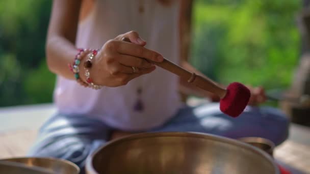 Superslowmotion plan d'une femme maître de la médecine sacrée asiatique effectue des bols tibétains rituel de guérison pour une jeune femme cliente. Méditation avec bols chantants tibétains. Ils sont dans un belvédère pour — Video