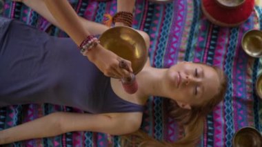 Asya kutsal tıp bir kadın ustası Superslowmotion atış bir müşteri genç kadın için Tibet kase şifa ritüel gerçekleştirir. Tibet şarkı kaseleri ile Meditasyon. Onlar için bir çardak bulunmaktadır